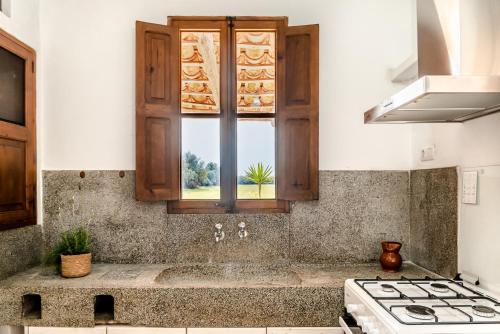 a kitchen with a stove and a window at Can Espina in Islas Baleares