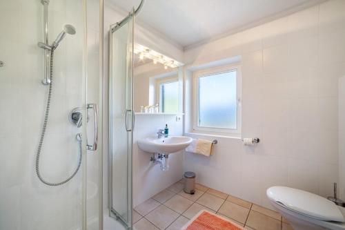 a white bathroom with a shower and a sink at Gasserhof Ferienwohnung Edelrot in Caines