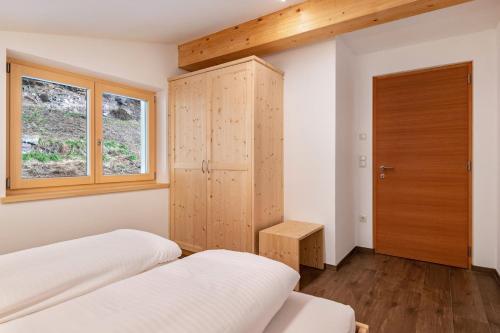 a bedroom with two beds and a wooden cabinet at Reiterhof Apt Flora in San Genesio Atesino
