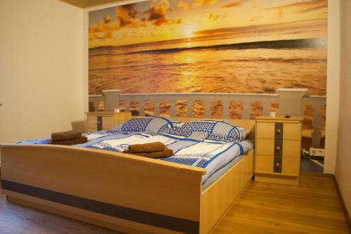 a bedroom with a bed with a painting on the wall at Ferienhaus Kiara in Westerhausen