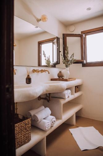a bathroom with a sink and mirrors and towels at The June Boutique in Benissa