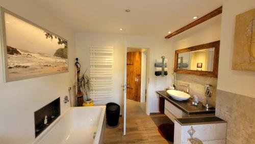 a bathroom with a tub and a sink and a mirror at Ferienwohnung Schwarzwald-Traum in Haslach im Kinzigtal
