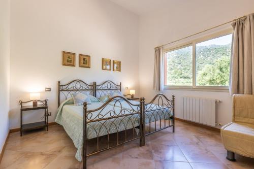 a bedroom with a bed and a large window at Harmònia Residence in Villasimius