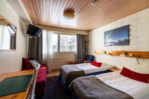 a hotel room with two beds and a tv at Santa's Hotel Tunturi in Saariselka