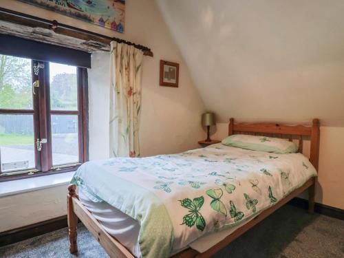 a bedroom with a bed and a window at Cider House - near Lyme Regis in Axminster