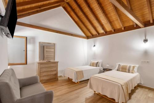 a bedroom with two beds and a chair at Vista Valle in Mogán