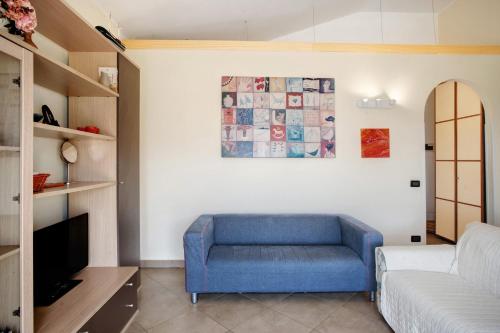 a living room with a blue chair and a couch at Villa di Diana in Diano Castello