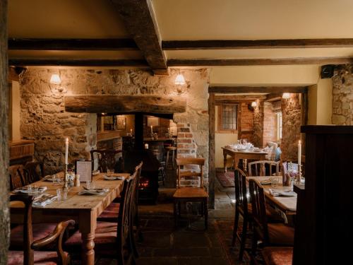 a restaurant with wooden tables and chairs in a room at The Queen's Head in Broad Chalke