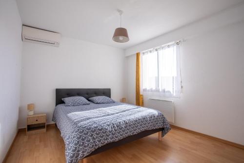 a bedroom with a bed and a window at Cocooning proche plage in Fréjus