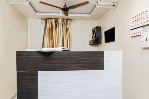 a room with a ceiling fan and a counter top at Laxmi Lodge in Pune