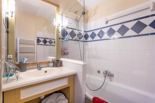 a bathroom with a sink and a tub and a mirror at Maison Village Port-Bourgenay in Saint-Hilaire-de-Talmont