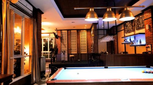 a pool table in front of a bar with lights at Amarelo Hotel Solo in Solo
