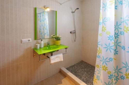 ein Badezimmer mit Dusche, Waschbecken und Spiegel in der Unterkunft Villa Jerónimo in Muro
