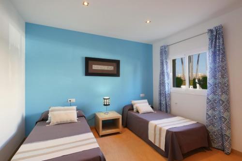 zwei Betten in einem Zimmer mit blauen Wänden in der Unterkunft Villa Jerónimo in Muro