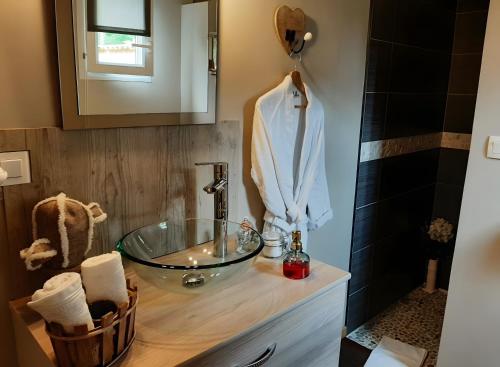 a bathroom with a glass sink and a mirror at Chambre d'hôtes Le Nid'zen in Le Nizan