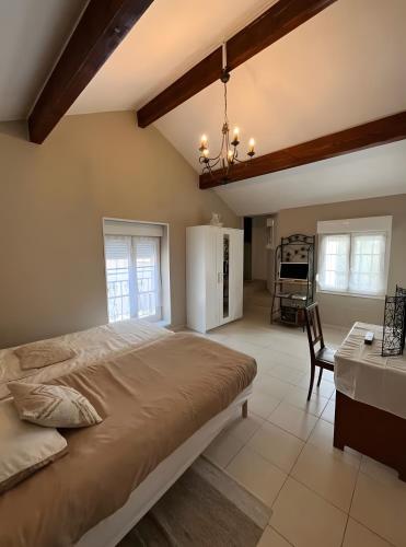 a large bedroom with a large bed and a table at A La Cour Basse in Peltre