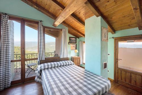 a bedroom with a bed and a large window at Casa Vittorina in Cesio