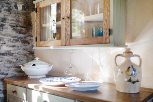 a counter with plates and glasses and a cabinet at Casa Vittorina in Cesio