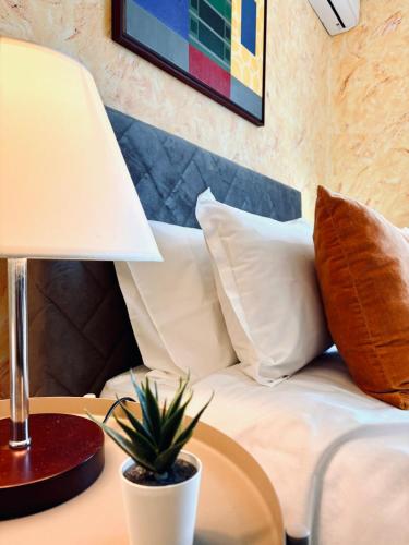 a bed with pillows and a table with a lamp at Casa Cataleia VILLA INN in Ponte de Lima