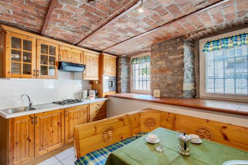 a kitchen with wooden cabinets and a table in it at Maison Jaccod_piano terra in Morgex