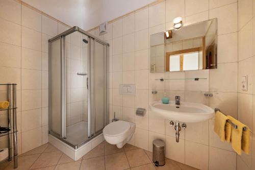 a bathroom with a shower and a toilet and a sink at Stompferhof Mansarde in Caldaro