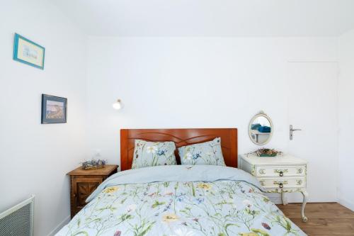 a bedroom with a bed with a wooden headboard at Chambres d'hôtes pleine nature in Plougonven