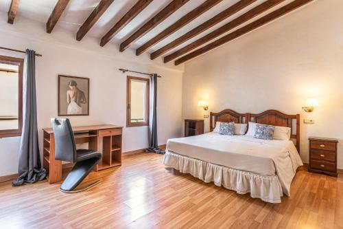 a bedroom with a bed and a desk and a chair at Ca Sa Cristeta de Sescola in Sa Pobla