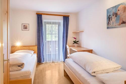 a room with two beds and a window at Stablerhof Apt Löwenzahn in Cornedo all'Isarco