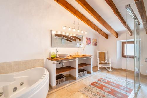 a bathroom with a bath tub and a sink at S'alqueria in Sóller