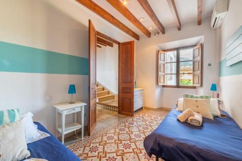a bedroom with a blue bed and a window at S'alqueria in Sóller