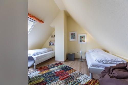 a attic room with two beds and a rug at Ferienwohnung Ulstrup in Böhl