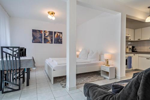 a living room with a white couch and a kitchen at Fewo Eg Mitte - Hunde erlaubt in Oberteuringen