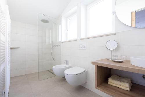 a bathroom with a toilet and a sink and a mirror at Kleon 1 in Rifiano