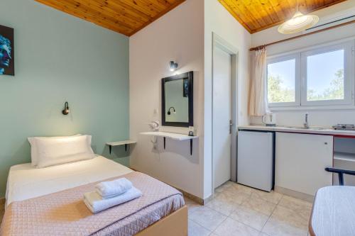 a bedroom with a bed and a sink and a window at Saint Peter Bay - Basic Room in Kavos