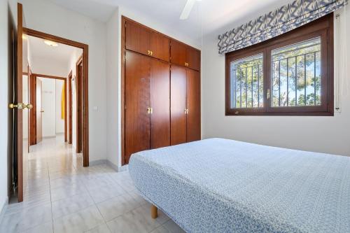 a bedroom with a bed and a window at Coma-ruga in El Vendrell