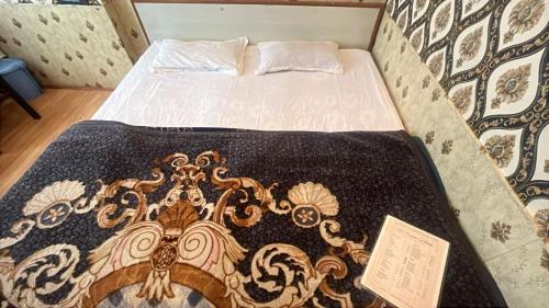 a bed in a room with a blanket on it at R Krishna Hotel in Srinagar