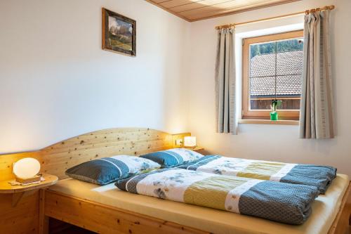 a bedroom with a bed with blue pillows and a window at Mongaduierhof Apt Panorama in Umes