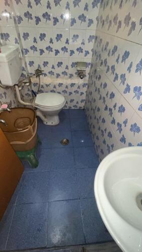 a bathroom with a toilet and a sink at R Krishna Hotel in Srinagar