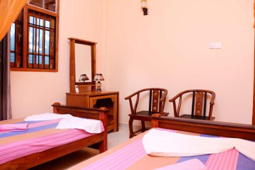 Habitación con 2 camas y espejo. en The Cool Nest Yala Hotel, en Tissamaharama