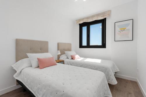 a bedroom with two beds and a window at Adhara 053 in Torre del Mar
