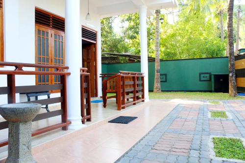 a front porch of a house with a green wall at The Cool Nest Yala Hotel in Tissamaharama