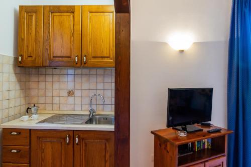 a kitchen with a sink and a tv on a cabinet at Capracotta - Sole in Montemassi
