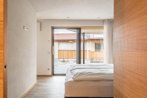 a bedroom with a bed and a large window at Aumia Apartment Saphir in Völs am Schlern