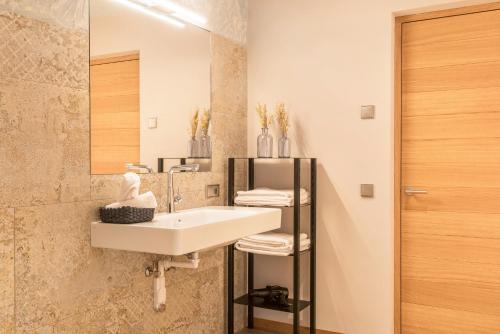 a bathroom with a sink and a mirror at Aumia Apartment Saphir in Völs am Schlern