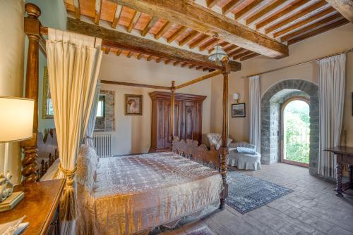 a bedroom with a canopy bed in a room with a window at Castello di Magrano in Gubbio