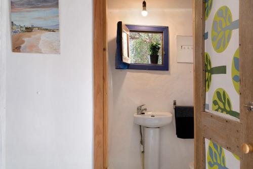 a bathroom with a sink and a toilet and a window at Aloe Art in Teguise