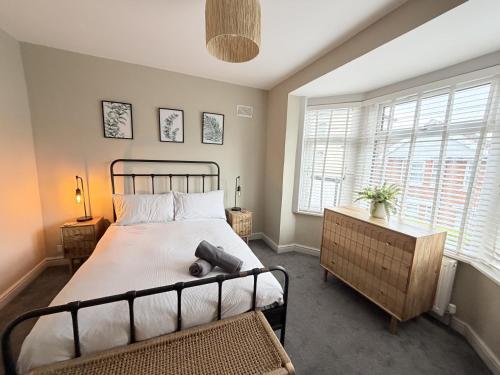 a bedroom with a bed and two windows at The Hideout in Southampton