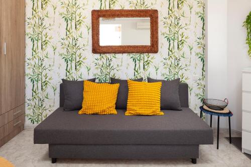 a bedroom with a bed with yellow pillows and a mirror at Torre del Mar Studio in Torre del Mar