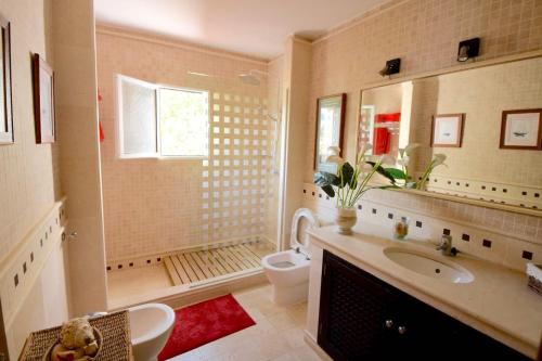 a bathroom with a sink and a toilet and a tub at La huerta de Bonela in Casarabonela