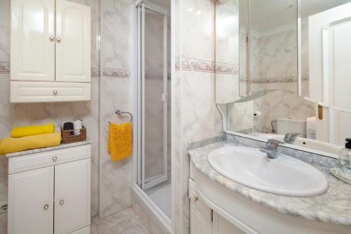 a white bathroom with a sink and a shower at Torre del Mar Studio in Torre del Mar